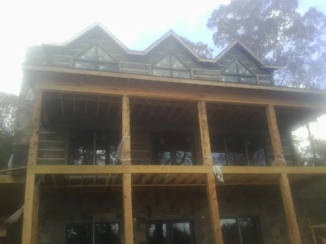 Dormers and porch framing on a large log home under construction — Roof Coating work by our crew in Duanesburg