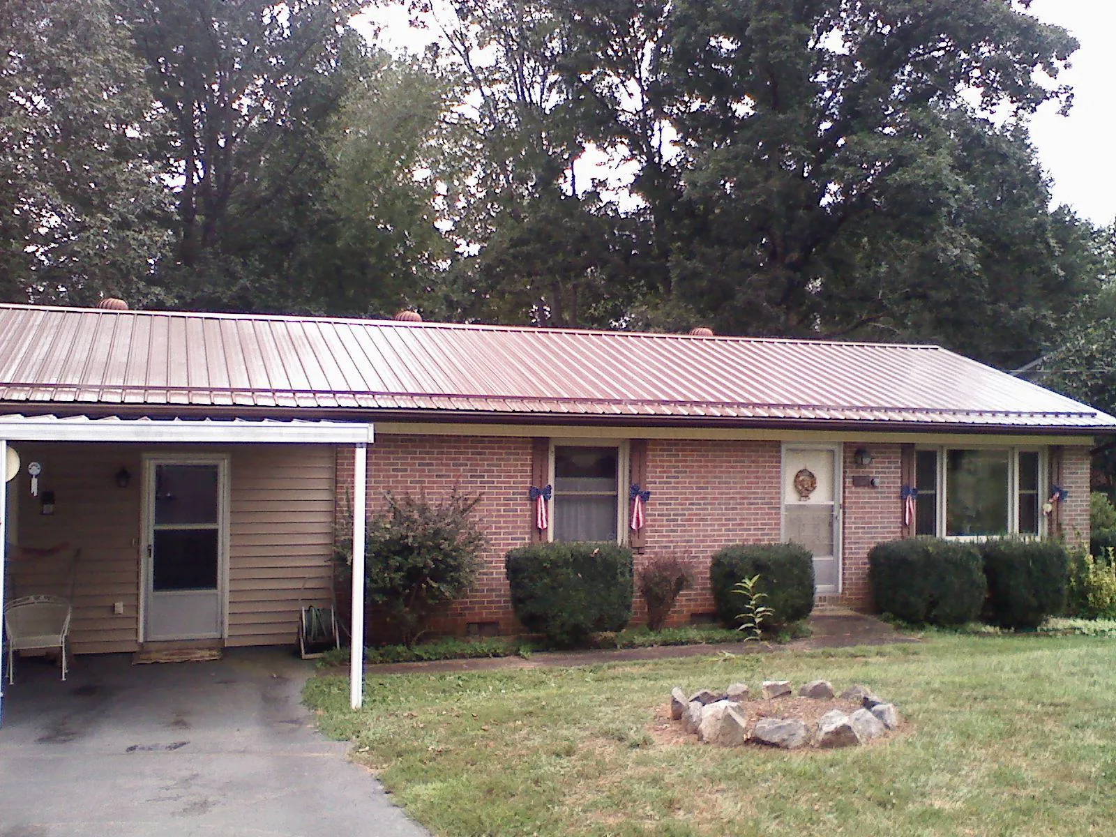 Bronze metal roof and carport on a brick ranch home — Roof Repair work by our crew in Duanesburg